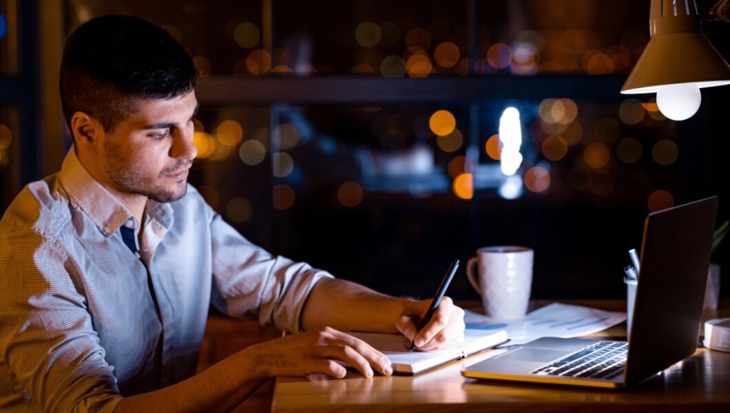 A man in his late 30s looking reflective in a office