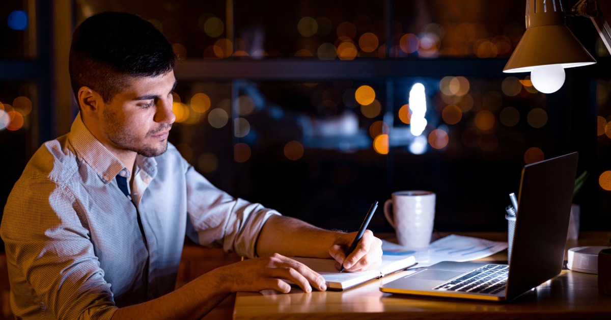 A man in his late 30s looking reflective in a office